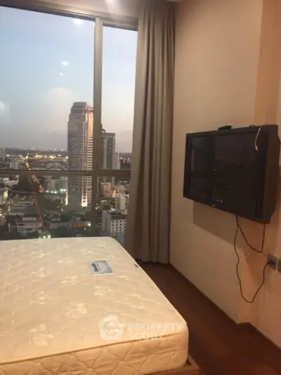 Modern bedroom with city view and wall-mounted TV in high-rise apartment