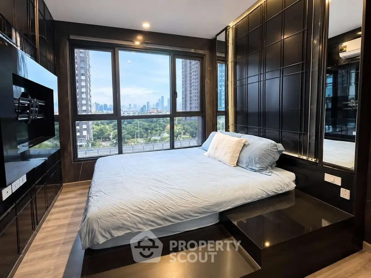 Luxurious bedroom with stunning city view and modern design in high-rise apartment.