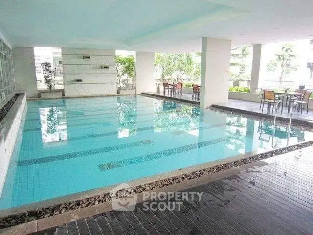 Luxurious indoor pool area with modern design and seating, perfect for relaxation and leisure.