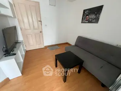 Cozy living room with modern decor, featuring a sleek sofa, flat-screen TV, and stylish wall art.
