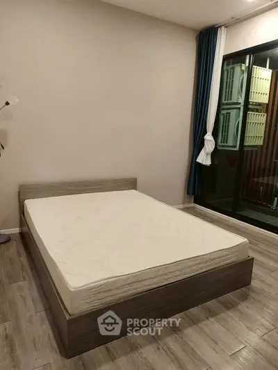 Spacious bedroom with modern design and large window for natural light.