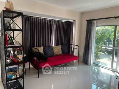 Spacious living room with modern decor and large window overlooking garden