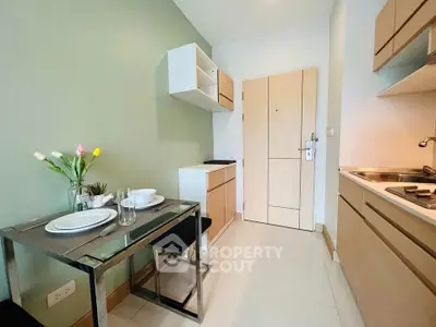 Chic modern kitchen with sleek cabinetry and dining area in compact apartment