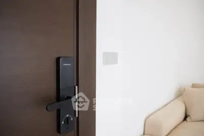 Modern interior with smart lock and cozy beige sofa in a minimalist setting.