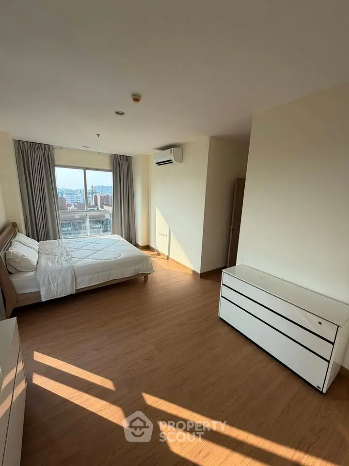 Spacious bedroom with city view and modern furnishings