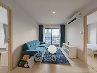 Modern living room with blue sofa and city view from balcony