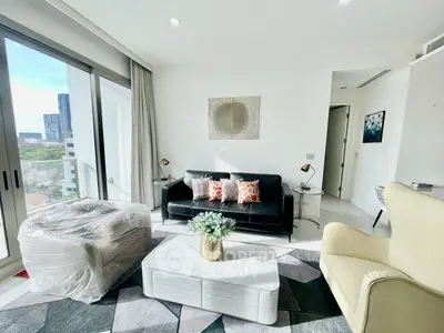 Modern living room with stylish furniture and large windows offering city views