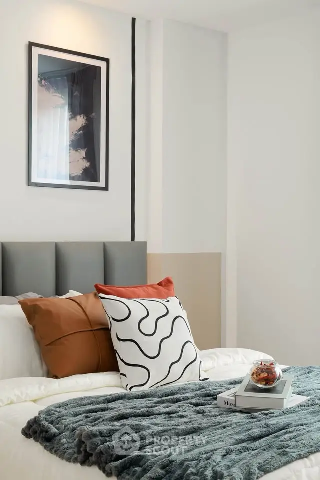 Modern bedroom with stylish decor and cozy bedding in a contemporary apartment.