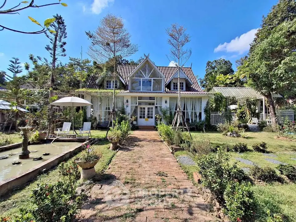 Charming countryside house with lush garden and pond, perfect for serene living.