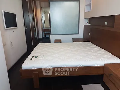 Spacious bedroom with modern furnishings and wall-mounted TV, ideal for comfort and relaxation.