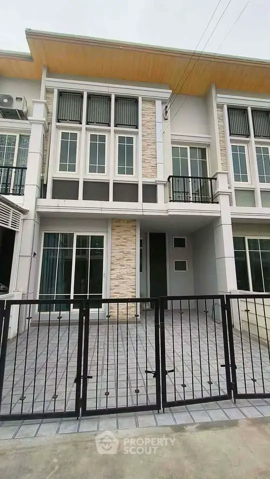Modern townhouse exterior with stylish facade and gated entrance, perfect for urban living.