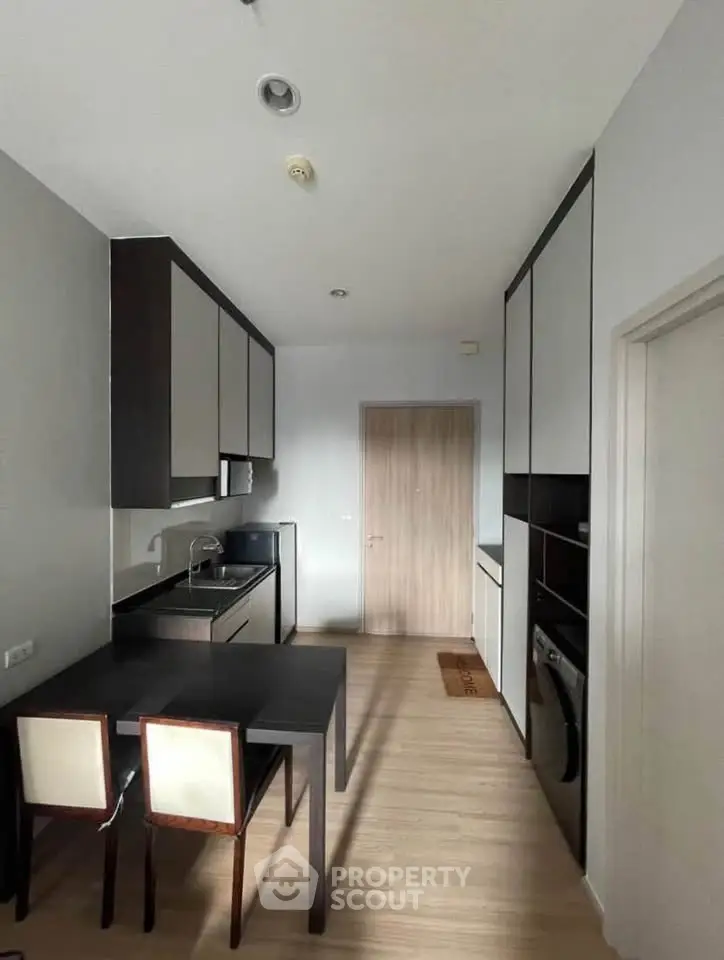 Modern kitchen with sleek cabinetry and dining area in stylish apartment