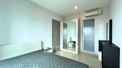 Modern bedroom with sleek design, featuring a mirrored wardrobe and air conditioning for comfort.