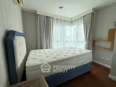 Spacious bedroom with large windows and modern decor in a stylish apartment.