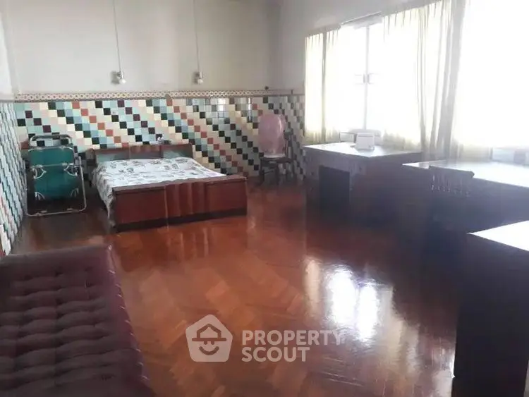 Spacious bedroom with unique tiled wall and wooden flooring