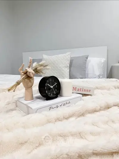 Cozy bedroom with stylish decor, featuring a plush bed, elegant pillows, and modern accessories for a serene ambiance.