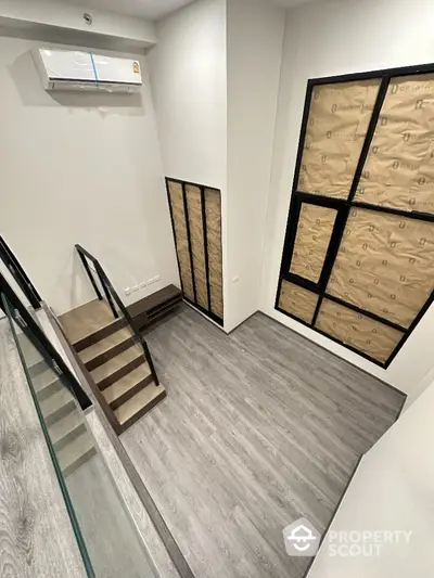 Modern duplex interior with sleek staircase and air conditioning unit