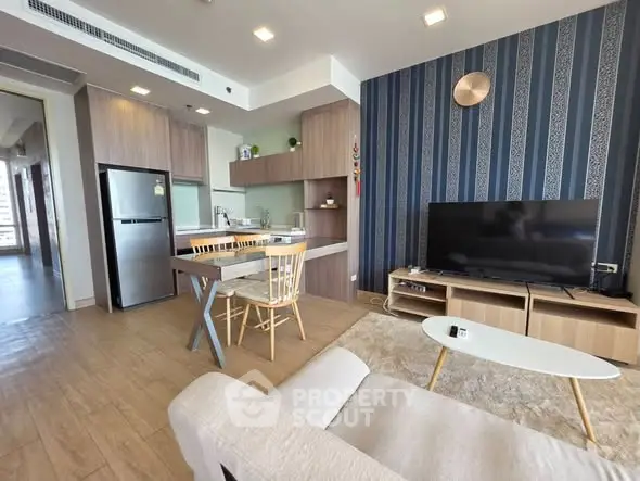 Modern open-plan living room with stylish kitchen and cozy seating area, perfect for contemporary living.