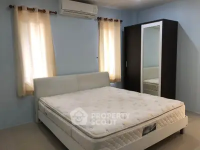 Cozy bedroom with modern furniture and natural light, featuring a comfortable bed and spacious wardrobe.