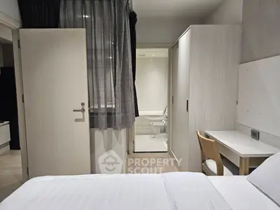 Modern bedroom with ensuite bathroom and study area, featuring sleek design and neutral tones.