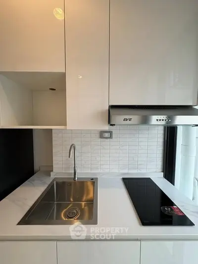 Modern kitchen with sleek white cabinets and built-in electric stove