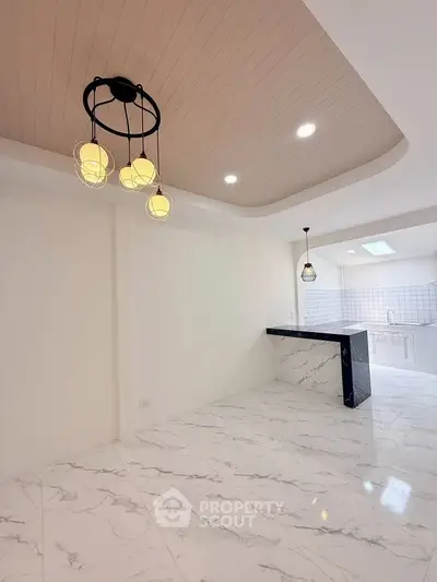 Modern kitchen with marble flooring and stylish lighting in open layout apartment.