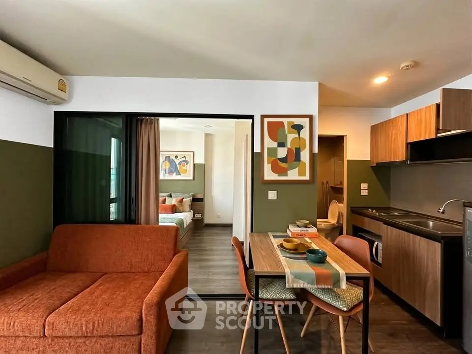 Modern open-layout apartment with stylish living room and kitchen, featuring contemporary decor and cozy bedroom.