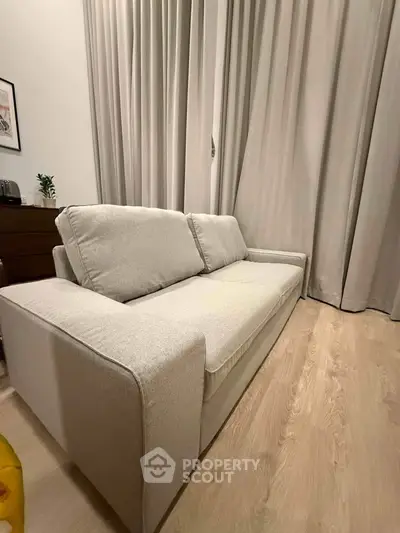 Modern living room with elegant beige sofa and floor-to-ceiling curtains