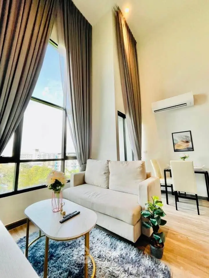 Luxurious high-ceiling living room with elegant decor and large windows offering stunning views.