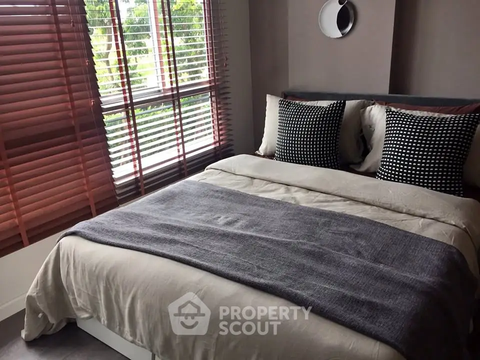 Cozy bedroom with stylish decor and large window for natural light.