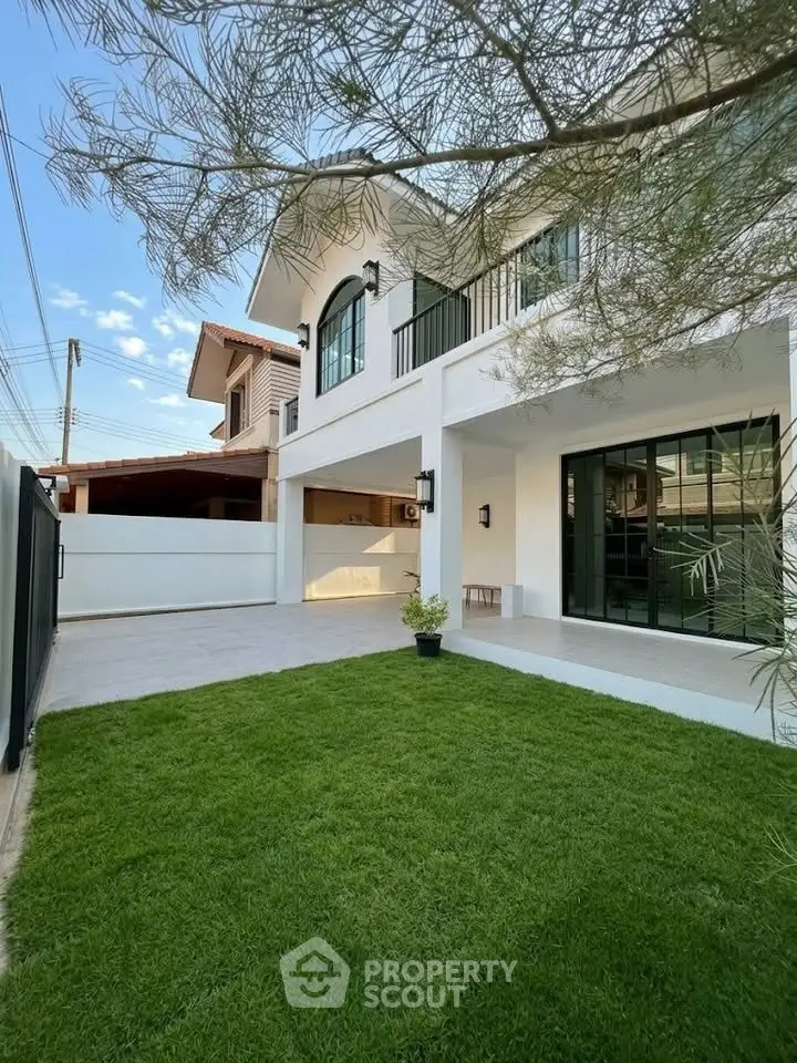 Modern two-story house with lush green lawn and spacious driveway in a serene neighborhood.