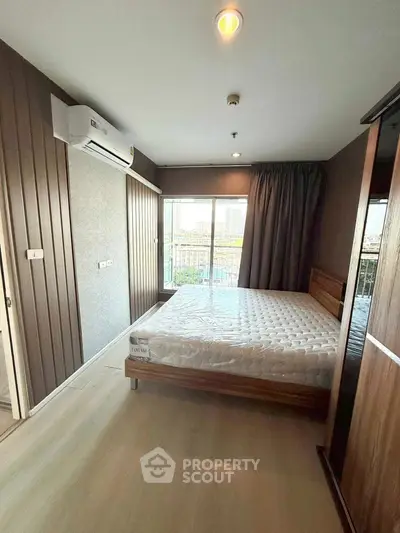 Modern bedroom with large window and city view, featuring a comfortable bed and air conditioning.
