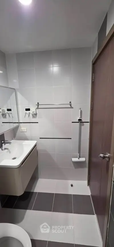 Modern bathroom with sleek design and wall-mounted sink in contemporary apartment.