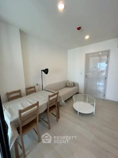 Cozy living room with dining area and modern furniture in a bright apartment.