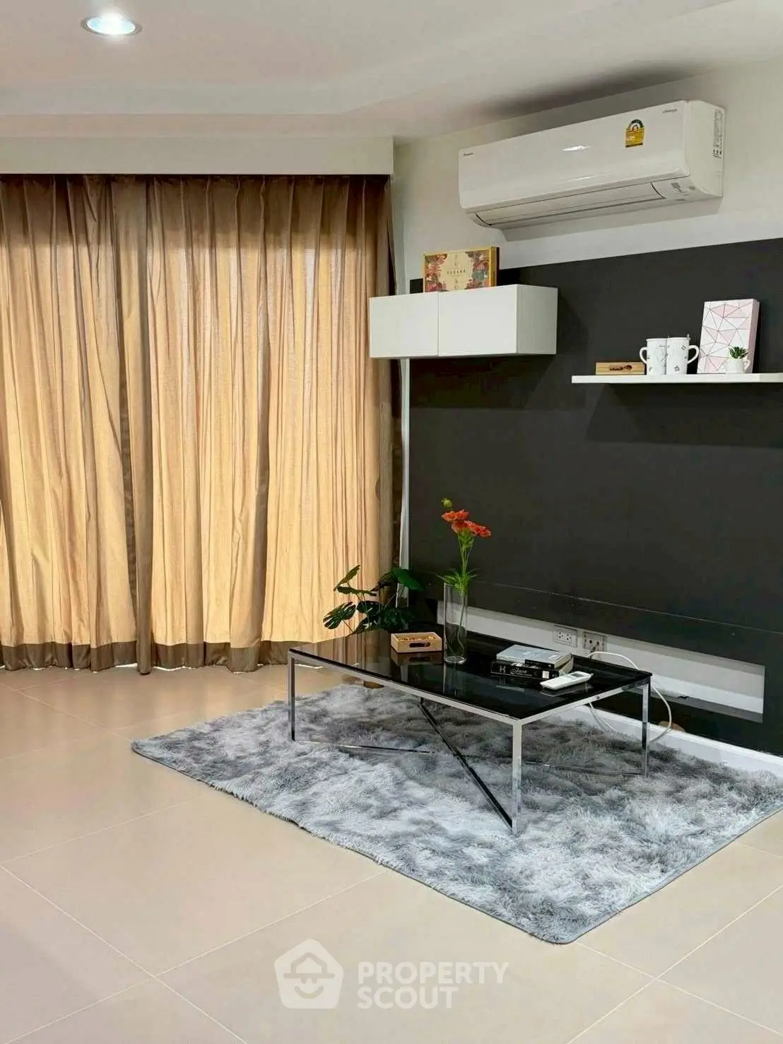 Modern living room with sleek decor and air conditioning unit, featuring a cozy rug and stylish shelving.