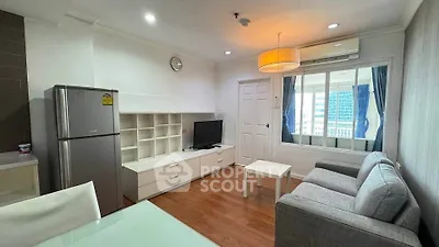 Modern living room with sleek furniture and natural light, featuring a cozy seating area and a stylish kitchen.