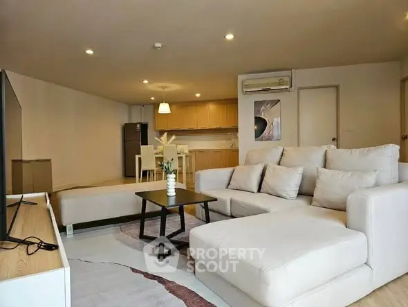 Spacious modern living room with cozy sectional sofa and open kitchen layout.