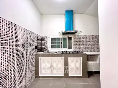 Modern kitchen with mosaic tiles and gas stove in stylish apartment