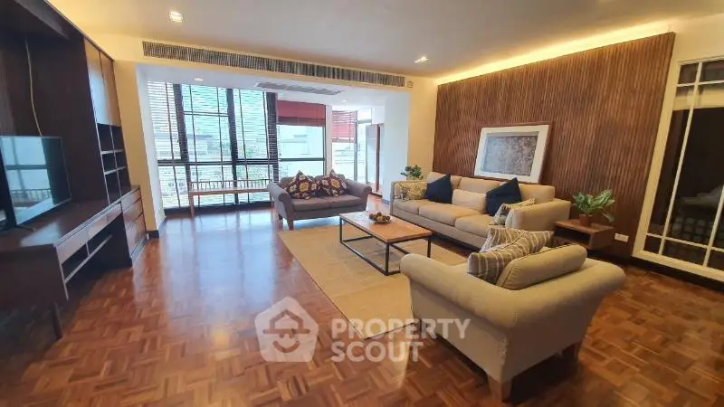 Spacious living room with elegant decor and large windows offering natural light.