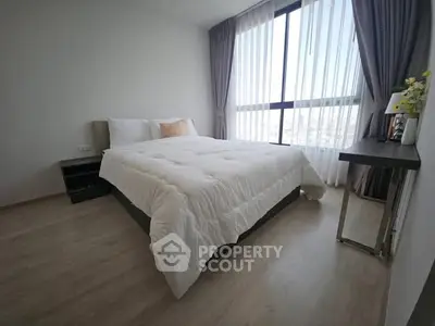 Modern bedroom with large window and elegant decor in a high-rise apartment.