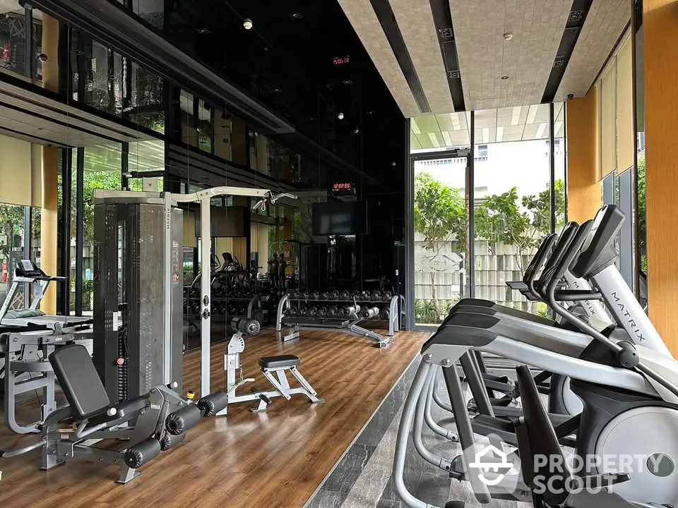 Modern gym with state-of-the-art fitness equipment and mirrored walls in luxury apartment complex.