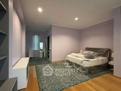 Spacious bedroom with modern decor and large windows for natural light.