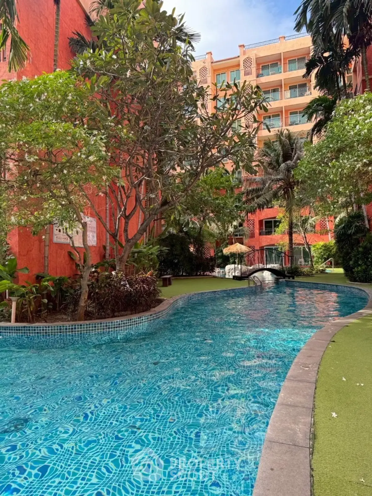 Luxurious residential pool area with lush greenery and vibrant architecture.