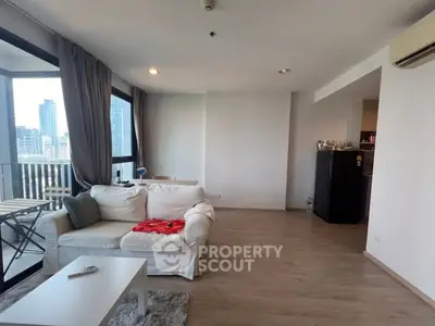 Spacious living room with city view and modern furnishings in high-rise apartment.
