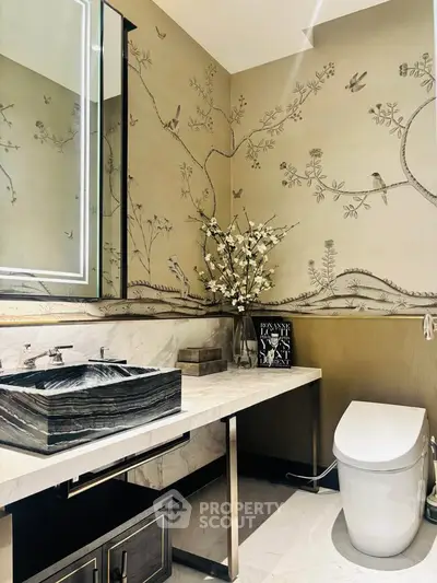 Luxurious bathroom with elegant wallpaper and modern fixtures, featuring a stylish sink and toilet.