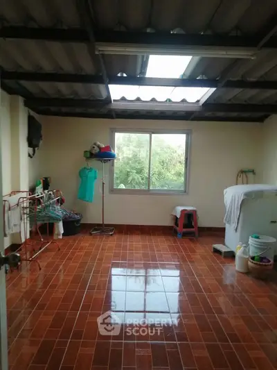 Spacious laundry room with natural light and tiled flooring, perfect for household chores.