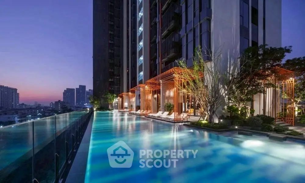 Luxurious high-rise building with stunning rooftop pool and city skyline view at dusk.