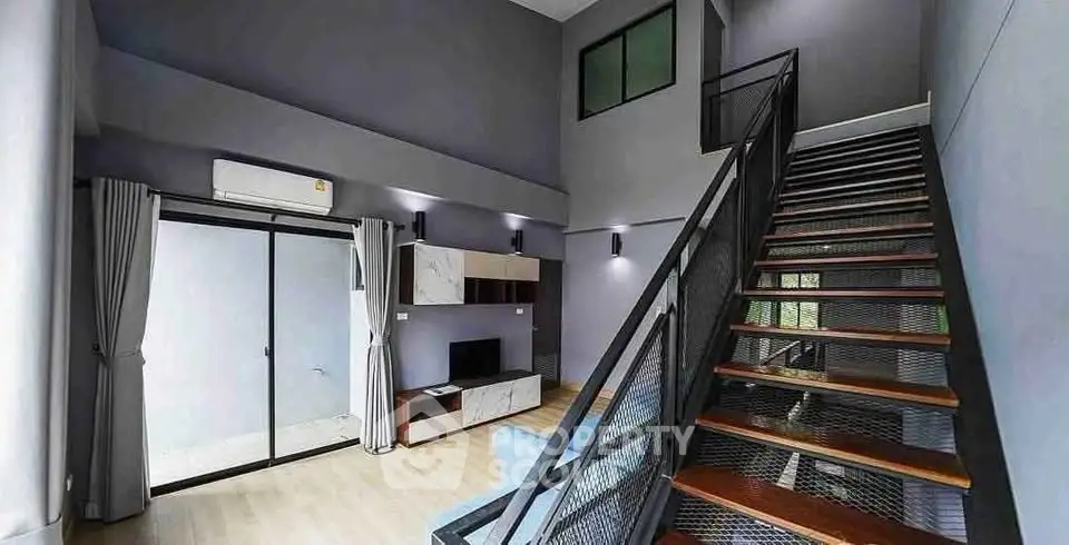 Modern duplex living room with high ceilings and stylish staircase