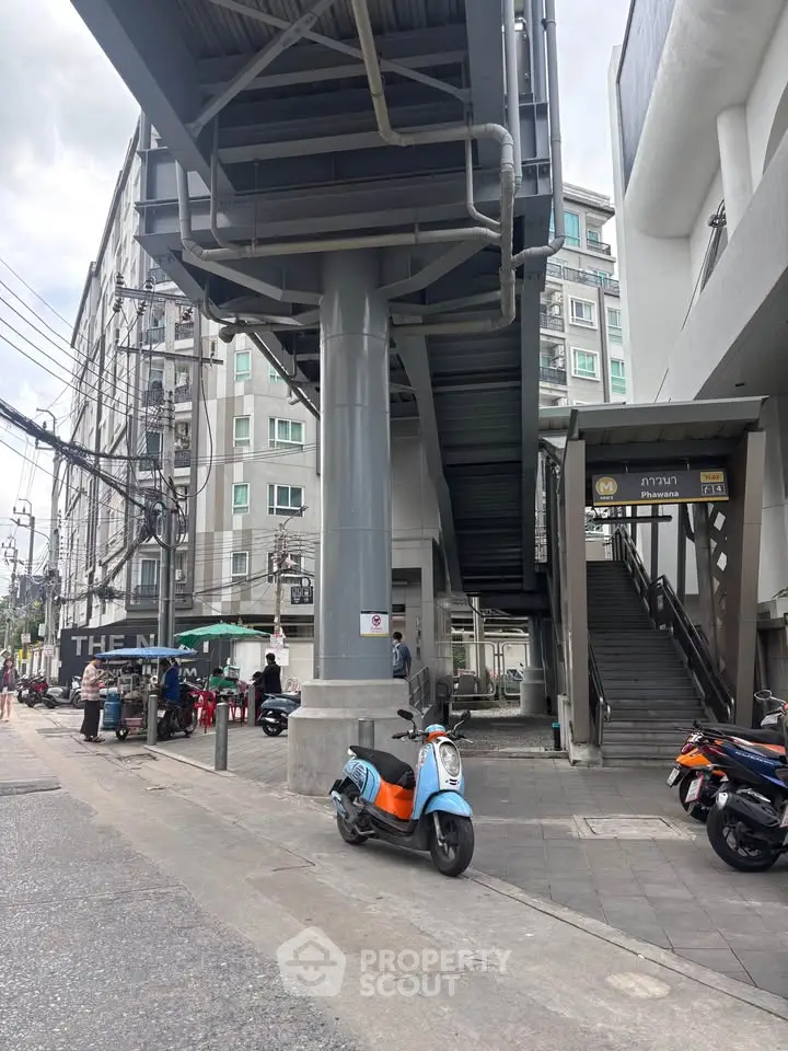 Urban street view with modern building and elevated walkway, showcasing city living convenience.
