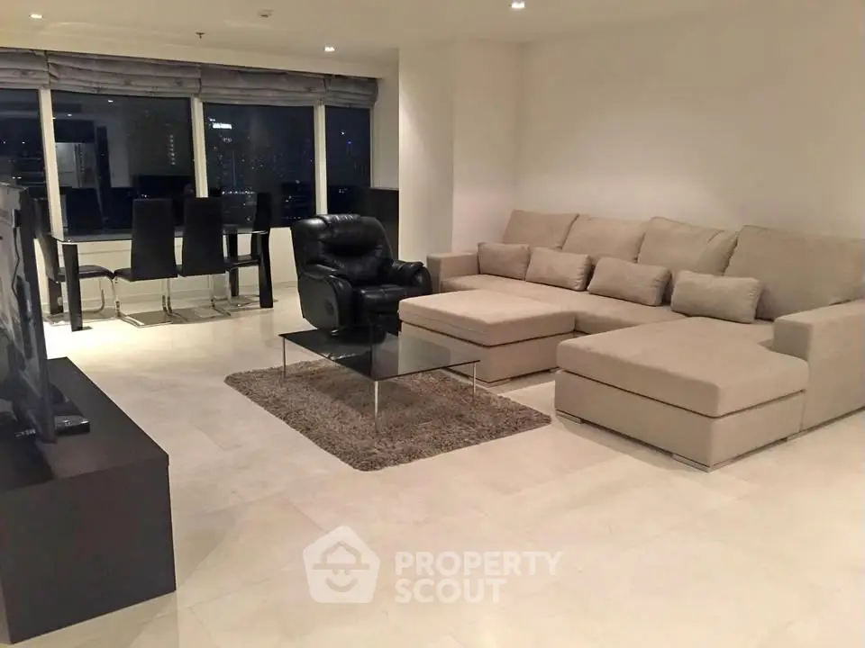 Spacious modern living room with large sectional sofa and dining area, perfect for entertaining.